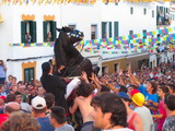 el caballo en el gran protagonistas en todas las fiestas patonales de los pueblos de menorca, con el jinete elevando el caballo en dos pata en medio del publico