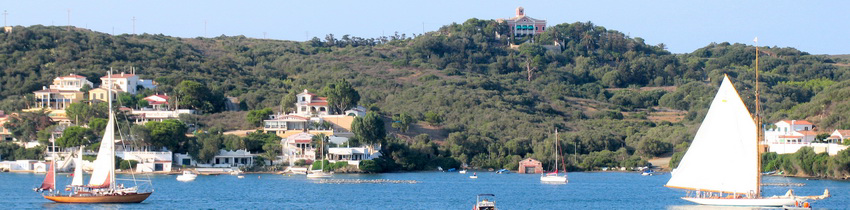 Los veleros de epoca surcan las aguas del puerto de Mahon, al fondo se ve la finca del pirata Varba Roja